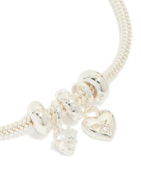 Featuring silver plated finish, this dainty bow and heart charm bracelet has cubic zirconia accents in close up view - link has visual effect only