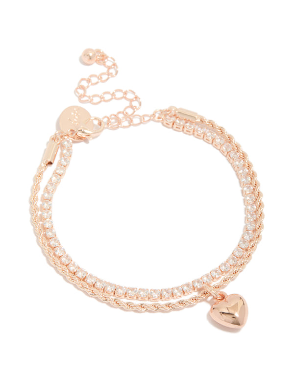 Showcasing a rose gold plated cubic zirconia tennis and heart layered bracelet with charm detail front view
