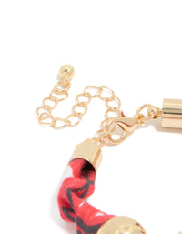Designed with beads accents in gold and red, this wrapped bracelet with stones closure detail view - link has visual effect only