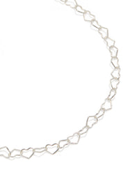 Showcasing sterling silver heart link bracelet in a close up view - link has visual effect only