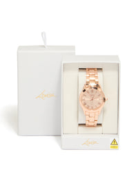 Presenting a rose gold classic round roman numeral watch with numbers, pink dial, women's link band, formal occasion, analog timepiece case detail view - link has visual effect only