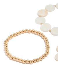 Showcasing gold beaded and genuine shell discs bracelets 4-pack with ocean-inspired design in ivory and beige close up view - link has visual effect only