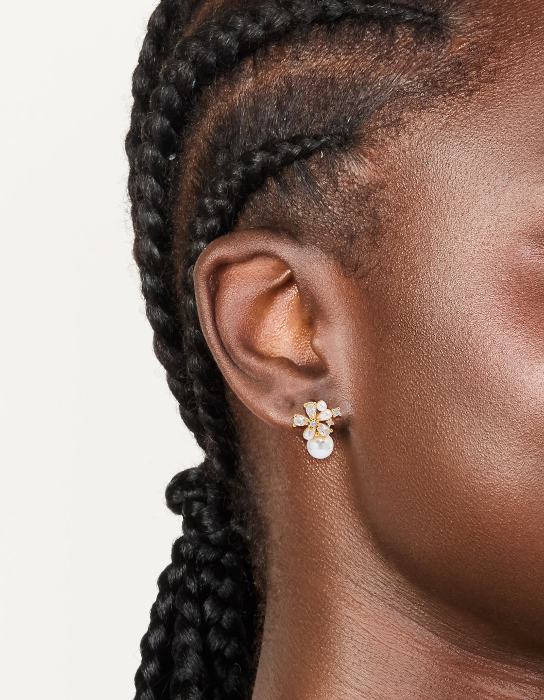 Designed with floral details, these gold plated cubic zirconia and pearl hoop earrings offer elegant styling on ear view