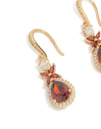 A detailed look at the intricate stone arrangement and metal texture on these statement drop earrings featuring dark red teardrop cubic zirconia with clear accents in gold, close up view - link has visual effect only