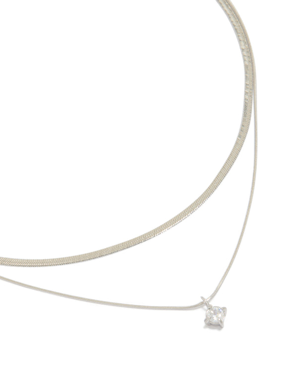 Showcasing a waterproof layered necklace featuring snake chain, round cubic zirconia, crystal accents, and stainless steel in silver close up view