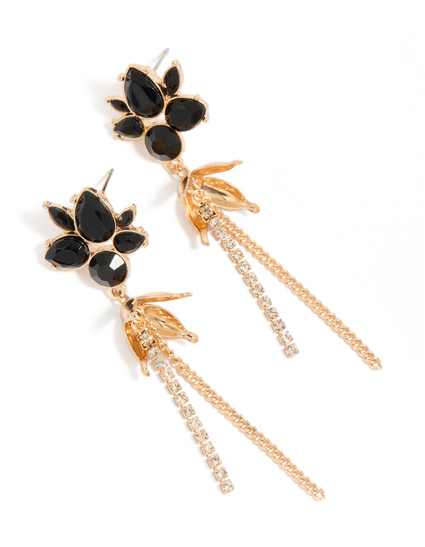 Showcasing statement drop earrings featuring charm design with black diamante flowers and gold chain tassels front view