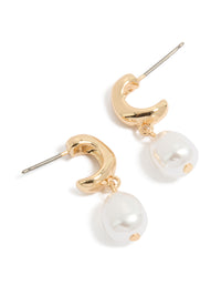 Showcasing gold pearl drop huggie earrings with huggie closure front view - link has visual effect only