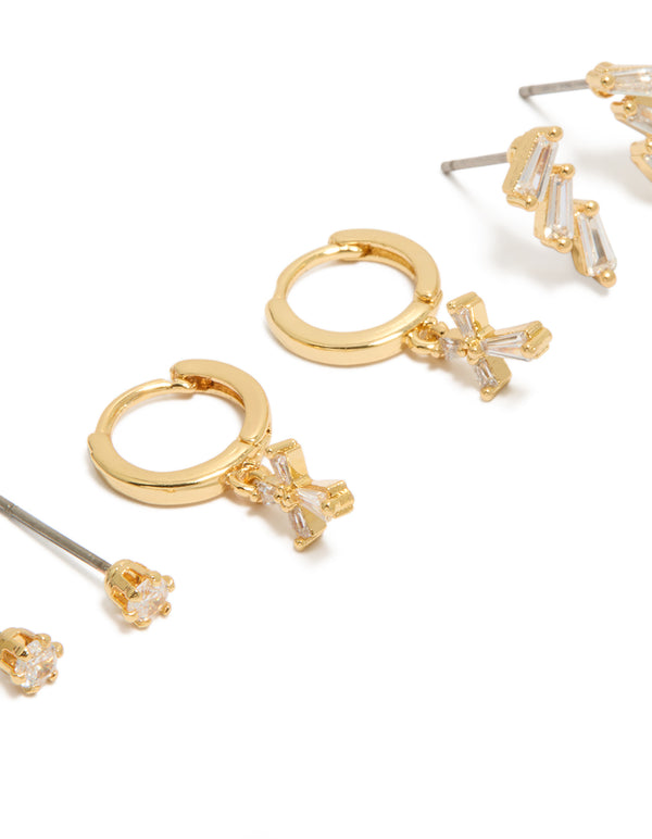 Featuring dainty cross cubic zirconia baguette trio studs and huggie earrings in a gold plated 3-pack close up view