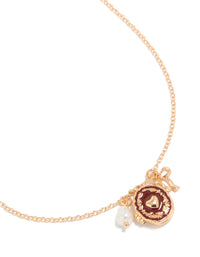 Showcasing a gold bow charm heart locket necklace with pearl pendant close up view - link has visual effect only