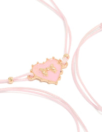 Showcasing heart charm bracelets crafted from cord and enamel in a 3-pack with light pink and gold tones close up view - link has visual effect only