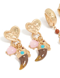 Crafted from worn gold, this statement earrings 3-pack with beads, charm, cross, heart, and huggie, stud closure close up view - link has visual effect only