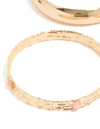 Featuring chunky gold textured and resin bangles in a 3-pack with peachpuff accents close up view - link has visual effect only