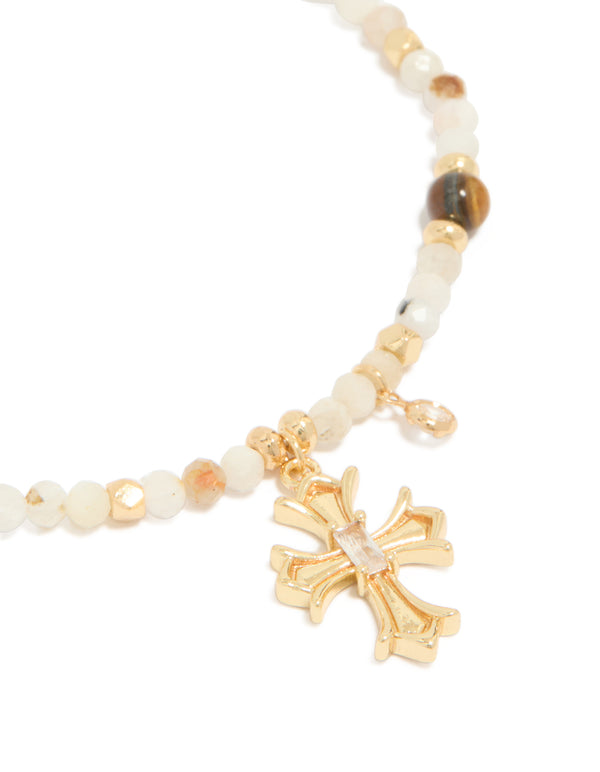 Designed with a gold plated beaded bracelet featuring cross charm and cubic zirconia crystal details close up view