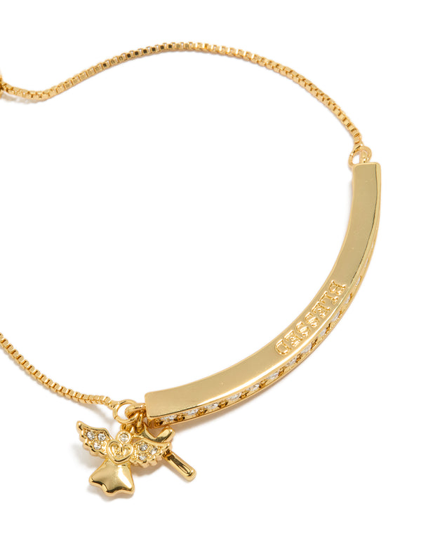 A close-up highlights the angel charm crafted from gold plated metal with cubic zirconia wings and celestial details on this statement toggle bangle close up view