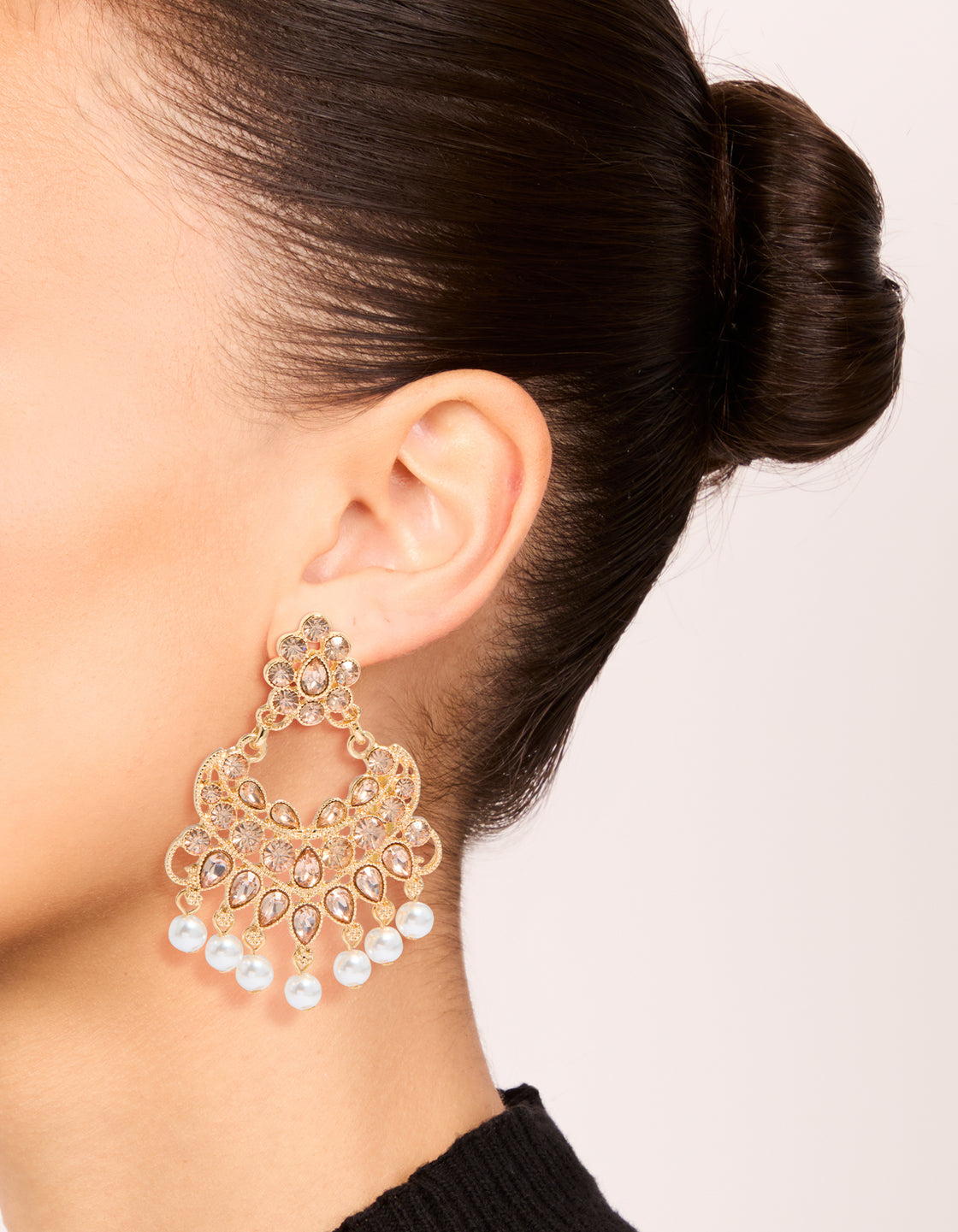 Elegant statement drop earrings featuring with charm and pearl in gold on ear view