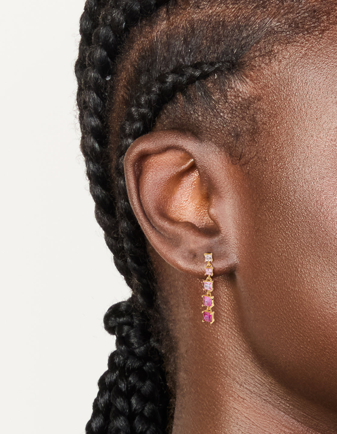 Showcasing gold pink cubic zirconia gradient drop earrings with statement design on ear view