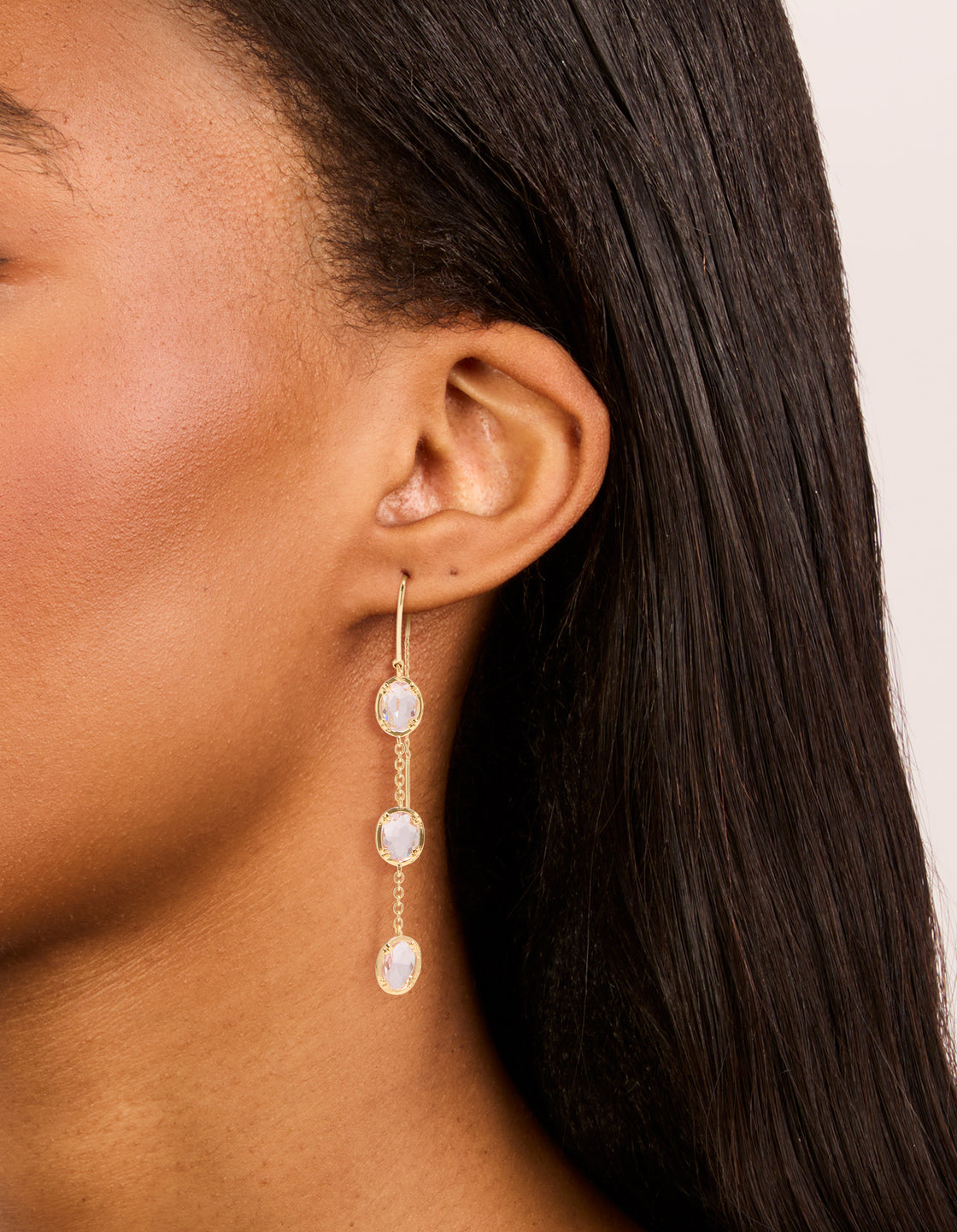 Elegant thread through earrings featuring statement dainty design with oval pink diamantes crafted from gold plated material on ear view