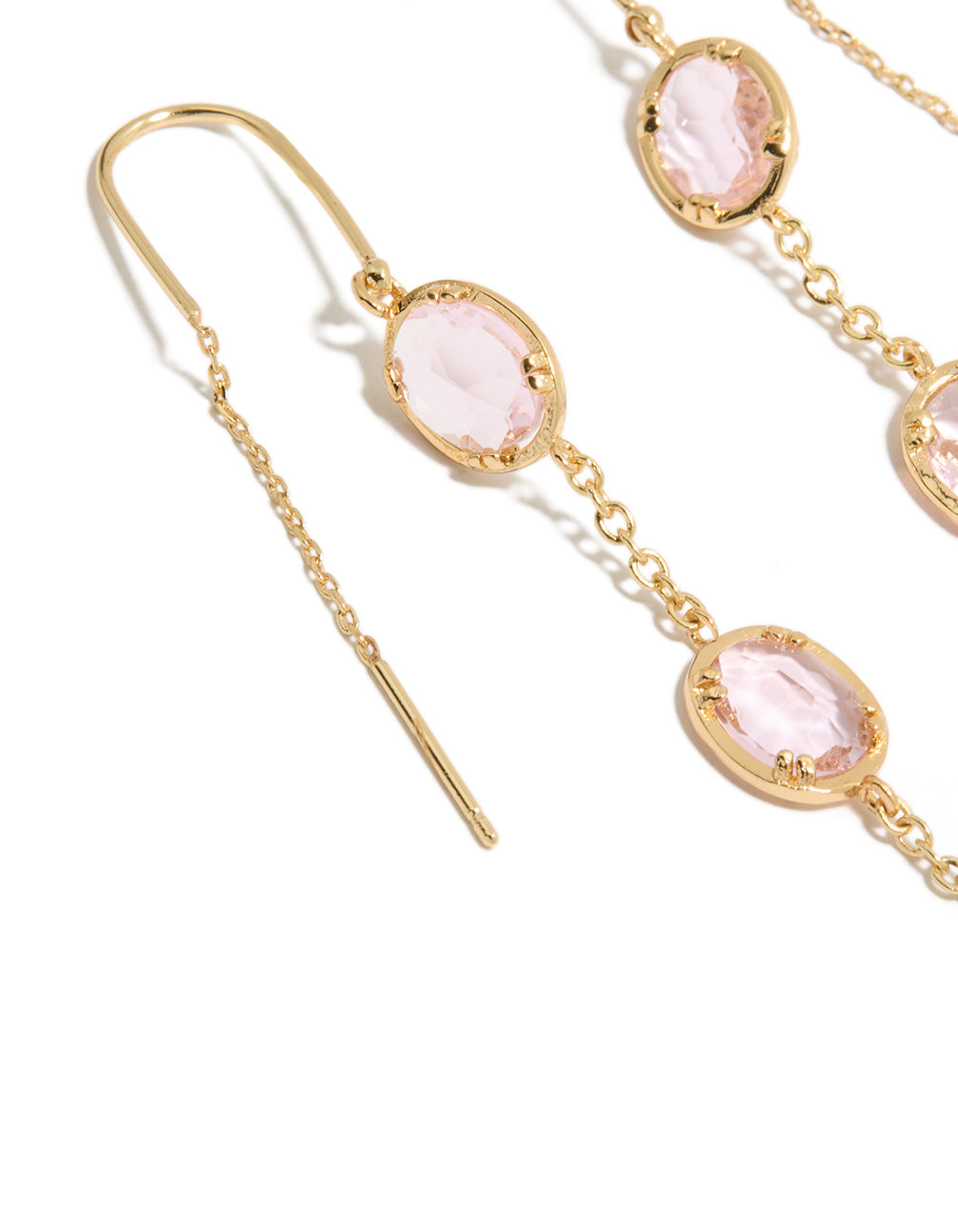 Detailed view of statement dainty thread through earrings featuring oval pink diamantes in gold plated material close up view