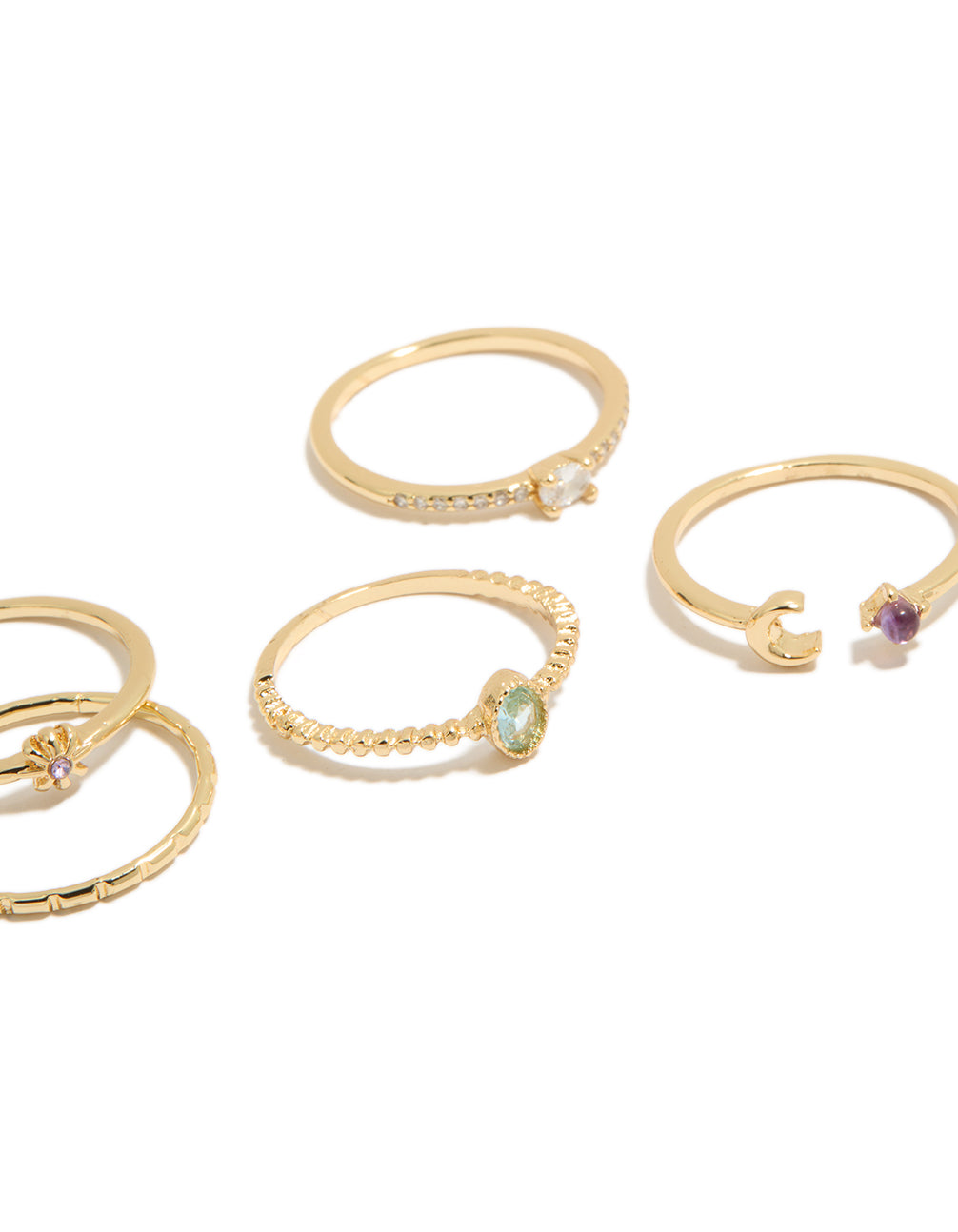 Highlighting gold celestial cubic zirconia rings 5-pack with sun, moon and oval stone cut in a dainty style close up view