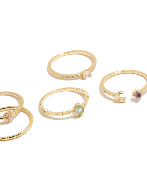 Highlighting gold celestial cubic zirconia rings 5-pack with sun, moon and oval stone cut in a dainty style close up view