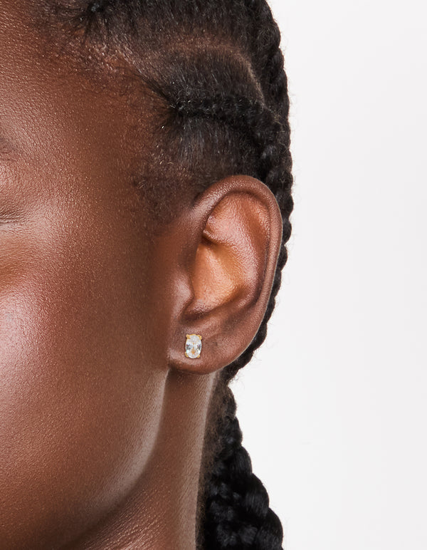 Featuring oval cut cubic zirconia studs in gold plated surgical steel with flat back closure on ear view