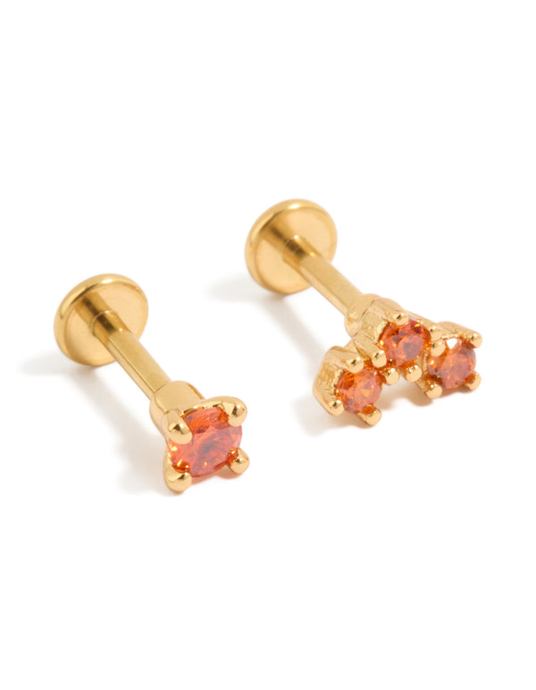 Showcasing titanium stud earrings with flat back closure in gold featuring red cubic zirconia stones front view