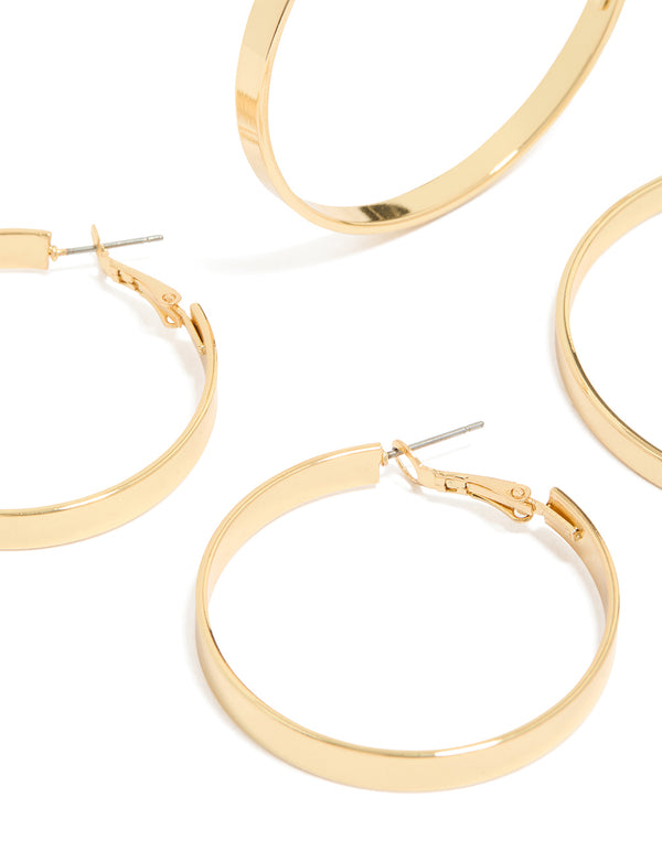Showcasing wide flat hoop earrings in a 2-pack, crafted from gold plated material with statement styling and hoop closure close up view