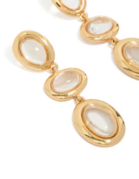 Showcasing statement clear circle drop earrings with gold plated finish in ivory close up view - link has visual effect only