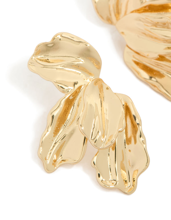 Crafted with intricate organic texture and petal detailing in statement half floral gold plated earrings close up view