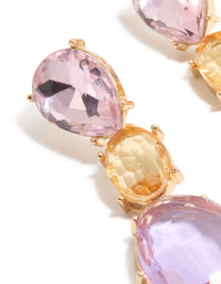 Showcasing statement drop earrings featuring purple and orange oval cut diamantes in gold close up view - link has visual effect only