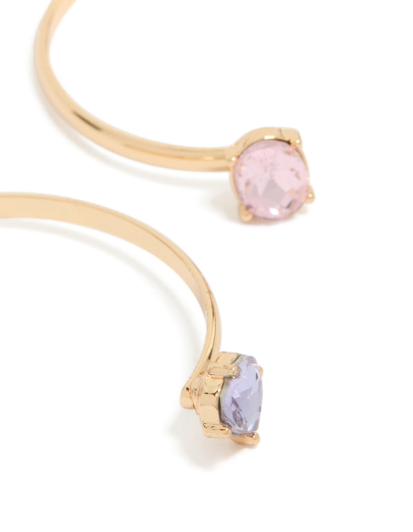 Highlighting gold wrist cuffs featuring pink and lavender diamante embellishments close up view