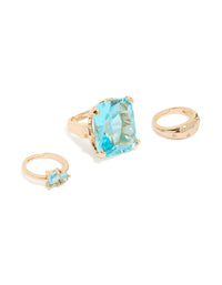 Showcasing gold clear and blue oversized diamante rings set with oval stone cut in statement style front view - link has visual effect only