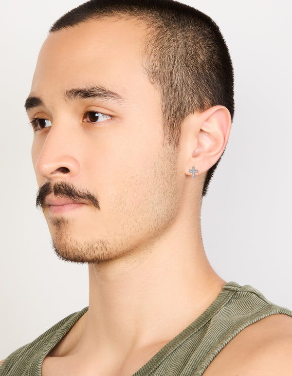 Highlighting mens waterproof stainless steel cubic zirconia cross detail stud earrings in silver and white on model view