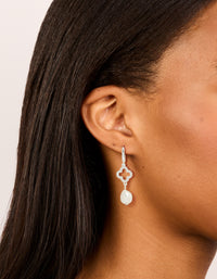 Showcasing silver plated pave clover pearl drop earrings with floral detail on ear view - link has visual effect only