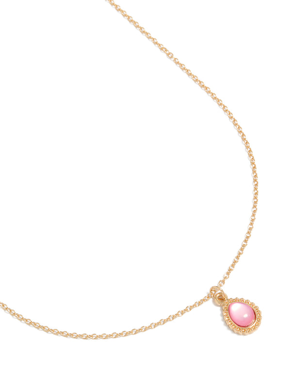 Showcasing a simple teardrop pendant necklace in gold with pink close up view