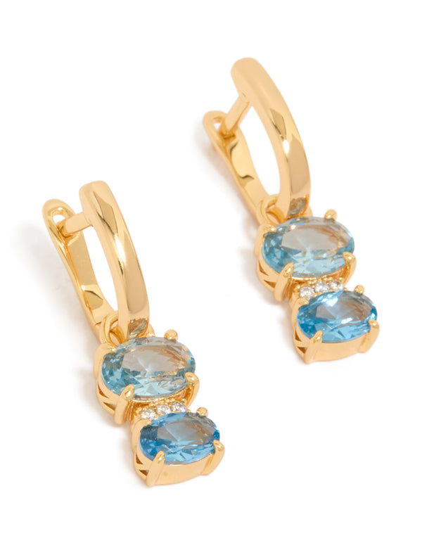 Showcasing gold plated light blue cubic zirconia circles huggie earrings with closure front view