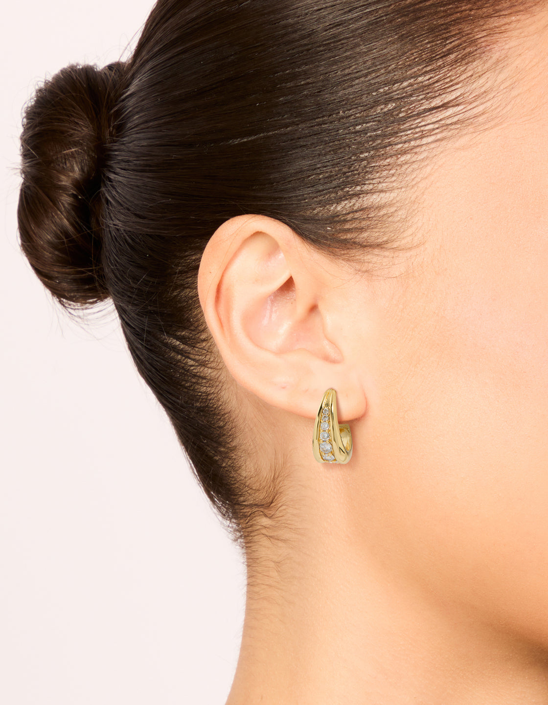 Crafted from gold plated cubic zirconia drop shaped hoop earrings on ear view