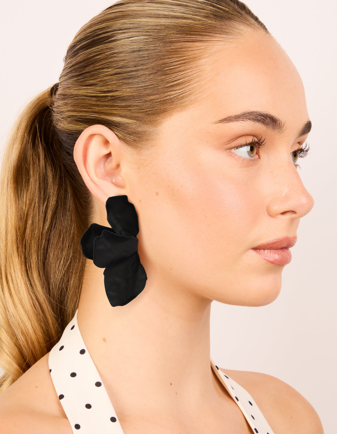 Designed with statement style, floral black coated metal half flower petal drop earrings on model view