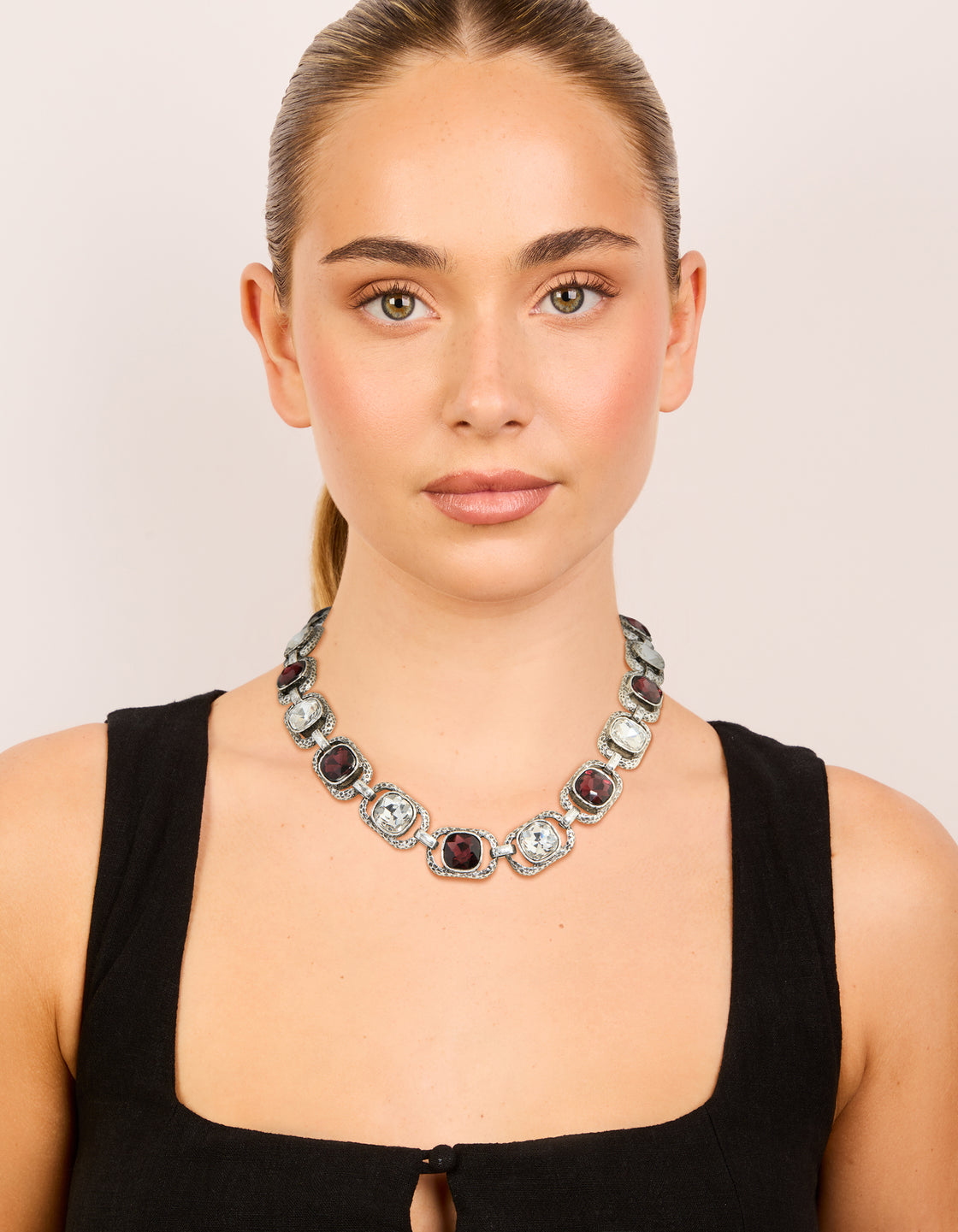 Discover this silver chunky necklace with clear and burgundy diamante details on model view