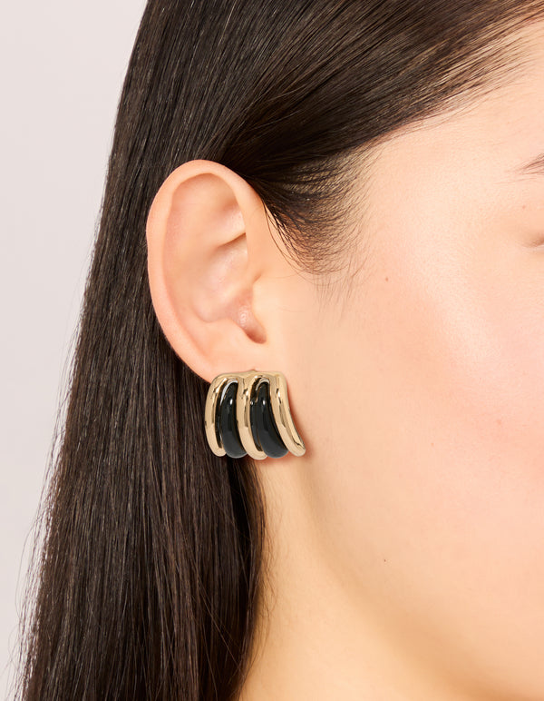 Featuring gold black double lined stud earrings with closure in on ear view