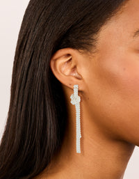 Showcasing silver plated cubic zirconia baguette knot drop earrings in clear on ear view - link has visual effect only