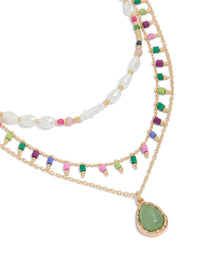 Showcasing a gold bead and pearl layered pendant necklace with charm featuring statement necklace close up view - link has visual effect only