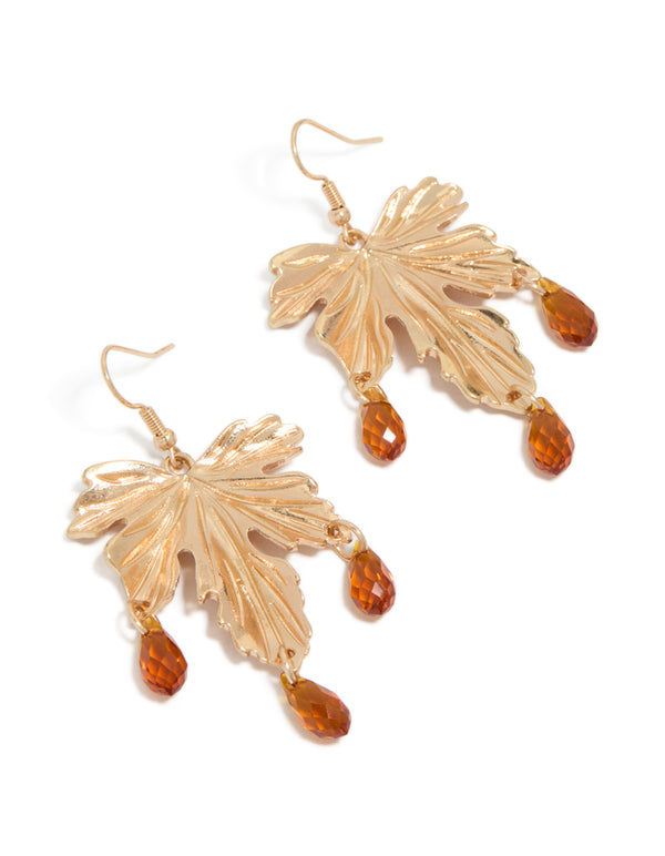 Showcasing statement drop earrings with floral leaf design featuring orange beads in gold front view