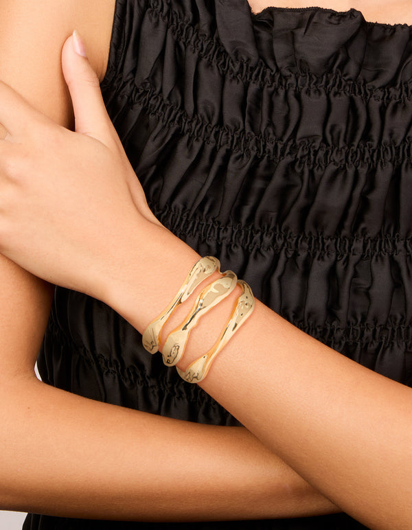 Featuring a gold irregular line wrist cuff in statement style on wrist view