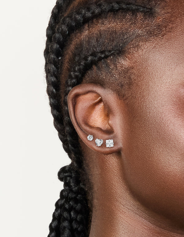 Showcasing waterproof stainless steel mixed stud earrings in a 3-pack featuring round cut cubic zirconia stones with silver and clear tones on ear view