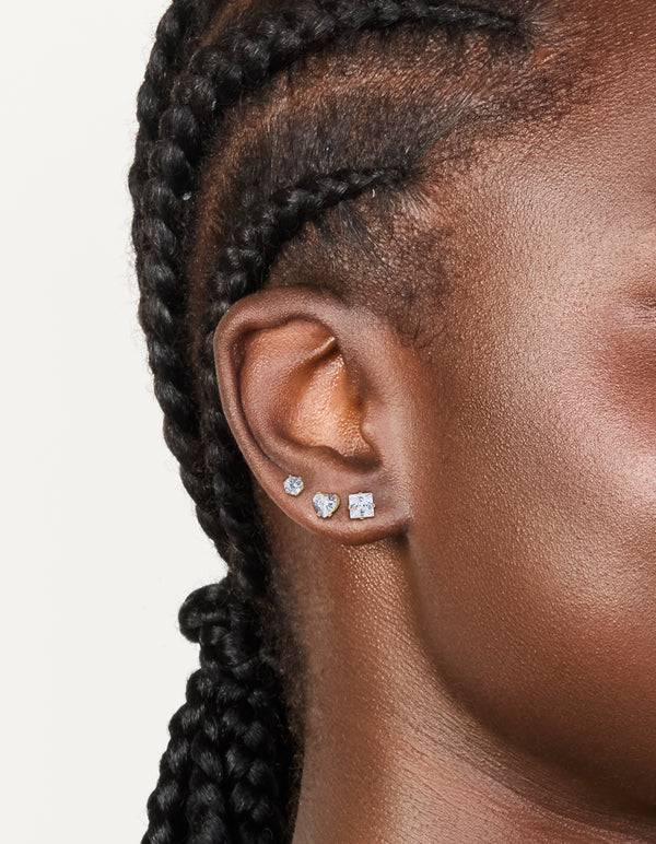 Crafted from waterproof gold plated stainless steel cubic zirconia mixed stud earrings in a 3-pack featuring round stone cut and clear accents on ear view