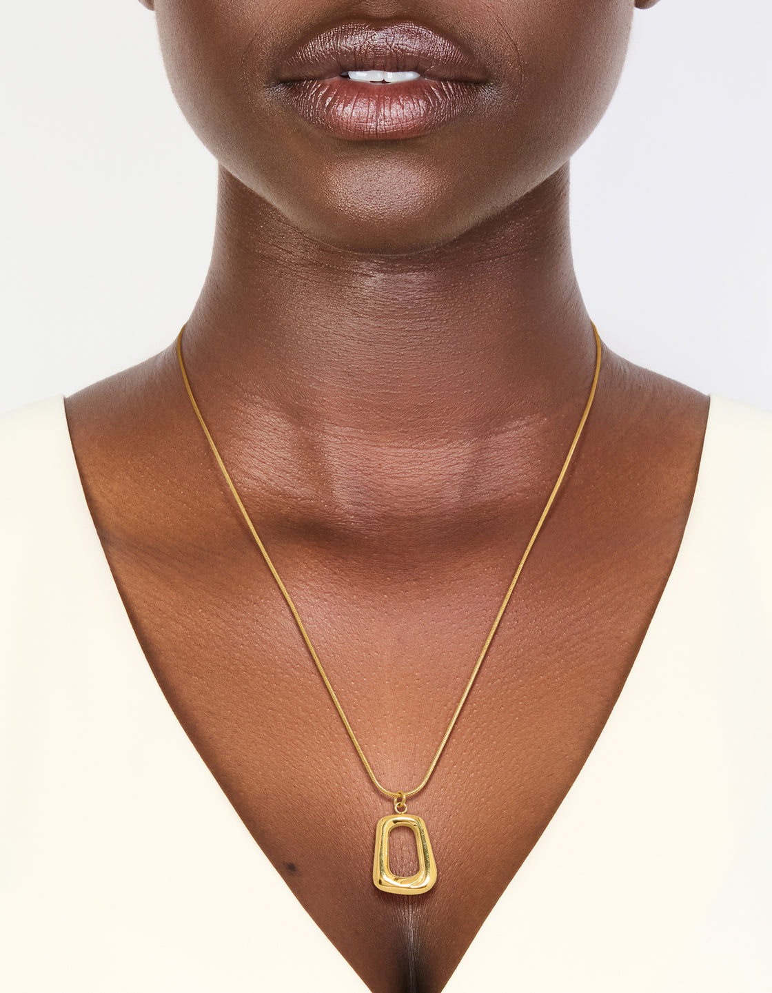Elegantly worn waterproof gold plated open rectangle pendant necklace in stainless steel on neck view