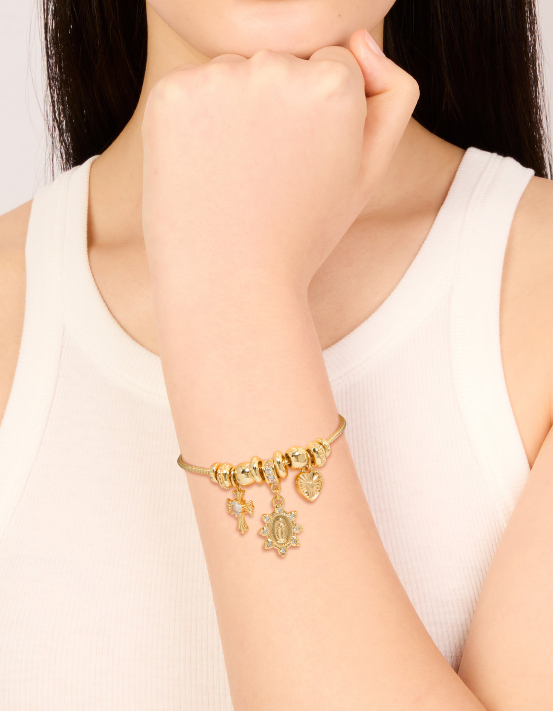 Stunning gold plated cubic zirconia heart and cross toggle bracelet featuring charms, and crystal details on wrist view