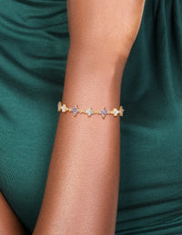 Highlighting a floral bracelet crafted from gold plated materials with cubic zirconia in purple on wrist view - link has visual effect only