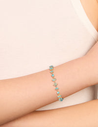 Featuring a gold plated blue large multi cut cubic zirconia tennis bracelet with blue stones and statement design on wrist view - link has visual effect only